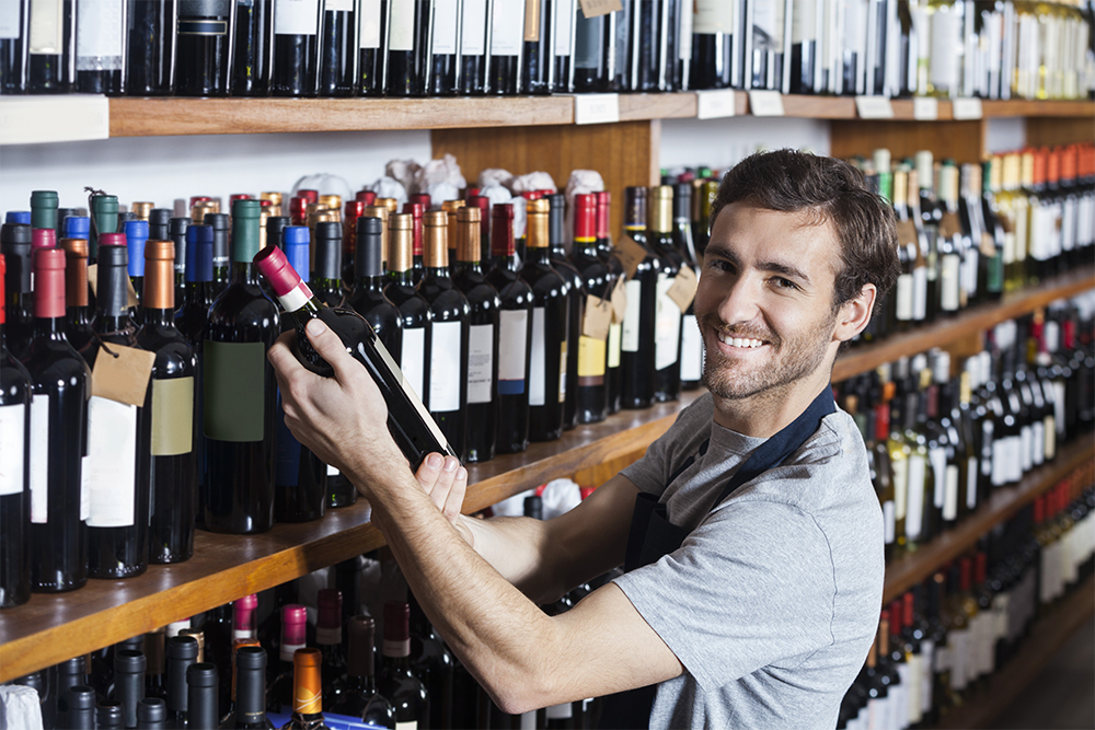 A liquor store worker stocking a shelf